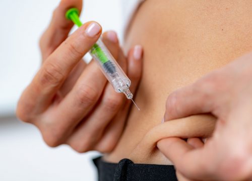 Photo of a man injecting his abdomen with semaglutide